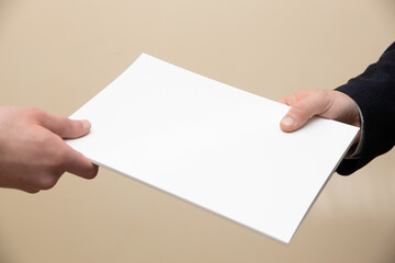 Businessman handing over a paper document to a fellow employee or customer.