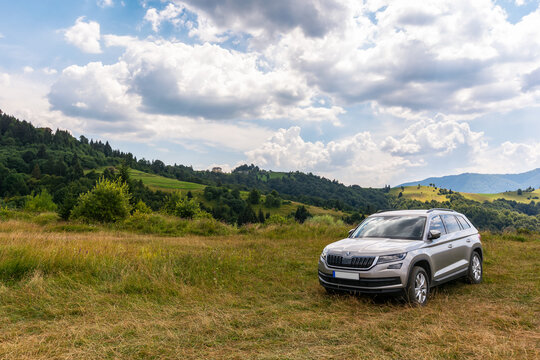 mizhirya, ukarine - AUG 08, 2020: suv on a hillside meadow. beautiful summer landscape on a sunny day. travel countryside and summer vacation concept