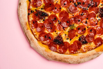 Pizza with Chorizo sausage, sweet pepper, sun-dried tomatoes, dried chilli, gouda cheese and mozzarella cheese with pilati sauce, thin crust and lush board. Pink background. Copy space. Top view