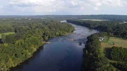 Gordijnen Bos rivier Aerial shot of Coosa river flowing between dense trees in Wetumpka, Alabama, Elmore County  © Donny Bozeman/Wirestock Creators