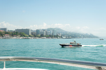 Obraz premium Motor ships and yachts on pier. Close-up. Wide landscape of the Black Sea. Sea trade port with mooring boats at sunset in Sochi, Russia