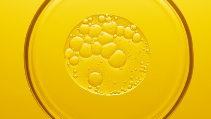 Close up view macro shot of gel with different sized bubbles spread out in petri dish on yellow background | Abstract skin care gel with hyaluronic acid formulating concept