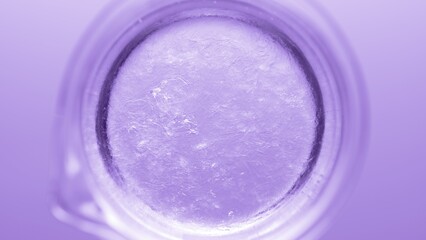 Top view macro shot of glycerin pouring into beaker with water creates ripples on its surface on violet background | Abstract body care cosmetics formulation concept