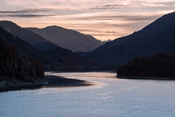 Alpiner Stausee Sylvensteinspeicher im morgendlichen Licht bei Sonnenaufgang an einem kalten Tag im Herbst 