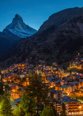 The night lights of Zermatt, Switzerland with the Matterhorn looming overhead - portrait format