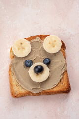 Funny children bear toasts with nuts butters for breakfast