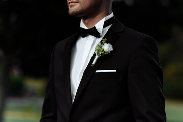 Boutonniere on the groom's jacket. Flower on a man's jacket. a man in a jacket with a flower.