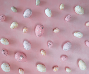 Pink, White and Yellow Decorative Eggs with Black, Silver and Gold Spots Lying in a Pink Background. Modern Easter Holiday Composition with Eggs on a Pink Backdrop. Top View. 