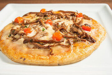 Vegan food, vegan pizza on a white plate, over wood, selective focus.