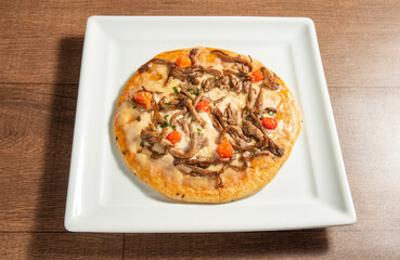 Vegan food, vegan pizza on a white plate, over wood, selective focus.