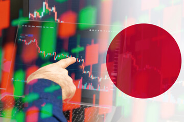 Japan downtrend of the economy in a world crisis. Man hand shows on the decreasing candle stick...