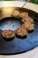 Chicken burgers cooking on an outdoor grill