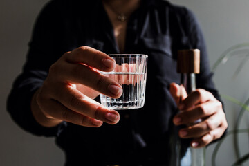 Bartender hands serving mexican mezcal shot in a traditional glass with tacos and food at...