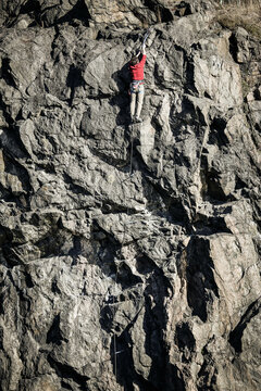 A climber tries to reach to top of a low mountain in central Stockholm, Sweden.