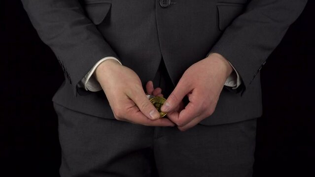 Young businessman in a suit takes out crypto coins