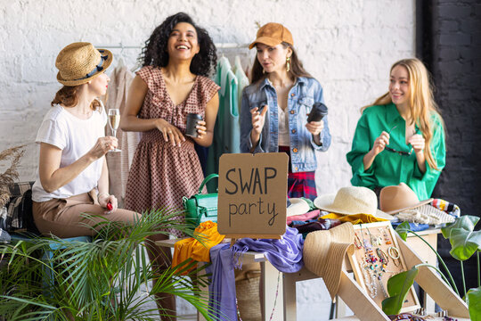 Young women at swap home party - clothes, shoes, bags, jewellery exchange between friends. Zero waste shopping, eco friendly concept, sustainable lifestyle. College life