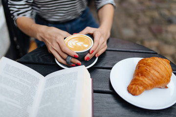 Close up of woman sitting at cafe with book and coffee