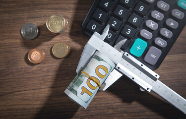 Caliper with a coins, money and calculator.