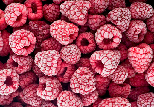 Frozen berries of raspberries, covered with hoarfrost as background. Top view.