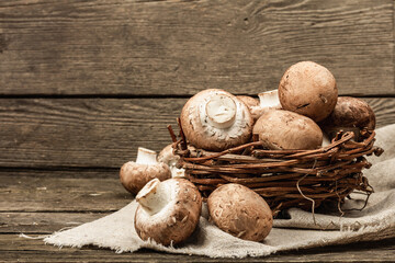 Fresh brown champignons in a wicker basket. Raw ingredients for cooking vegan food