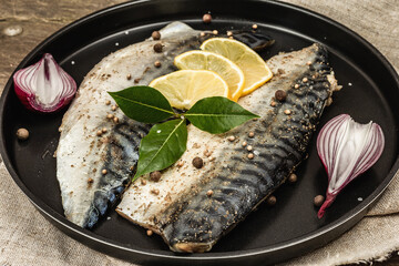 Marinated mackerel with spices and fresh bay leaves. Healthy food, ready to eat, served with lemon