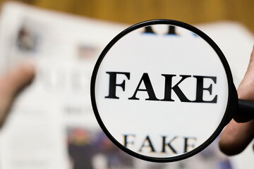 Leser hält Zeitung Nachrichten mit Fake News  Lupe
