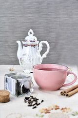 pink cup with lemon balm green tea, fine herbs cinnamon old teapot in the background