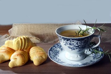 cup with lemongrass green tea, fine herbs cinnamon old crockery in the background