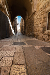 Fototapeta premium An old and ancient alley paved with stone tiles, in the Jewish Quarter - in the Old City of Jerusalem - Israel