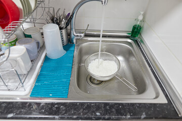 Cold water tap cooling the freshly cooked rice