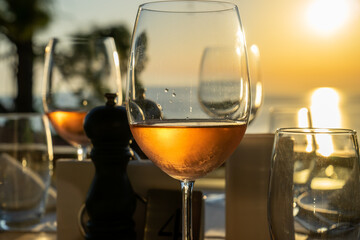Sunset wine and wine glass. Drink wine on sunset, mountain, trees and sea view.