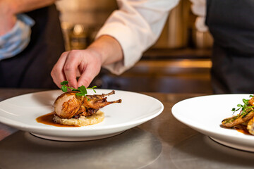 quail plated and prepared in kitchen by chef