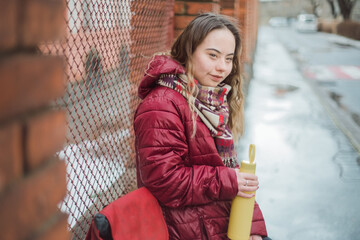 Happy young woman with Down syndrome resting in town in winter
