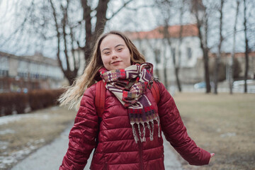Young woman student with Down syndrome walking in street in winter