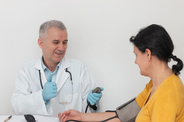 Mature doctor checking blood pressure of the woman