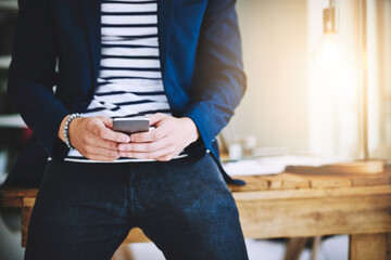His inbox fits right in his hands. Cropped shot of a businessman using a mobile phone in a modern office.