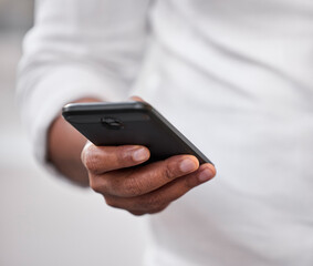 Ive got another meeting soon. Cropped shot of an unrecognizable businessman standing alone in the office and using his cellphone.
