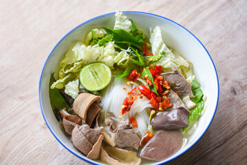 Noodle soup bowl pork blood pudding and pork offal, Thai rice vermicelli noodle with clear soup and fresh vegetable set with lemon sprouts bean pepper chili sauce Thai traditional menu food