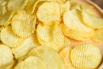 Potato chips texture background, Corrugated crispy potato chips snack on plate - top view