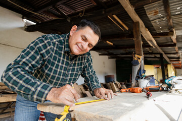 Mexican carpenter working in his workshop-Smiling mature man working in carpentry workshop-Happy...