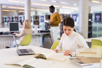 Successful woman studying in the library. High quality photo