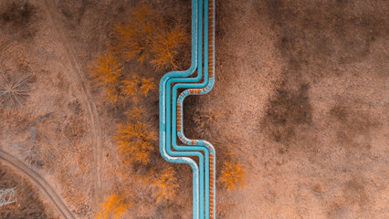 Blue pipeline over the fields. Abstract aerial view drone photo