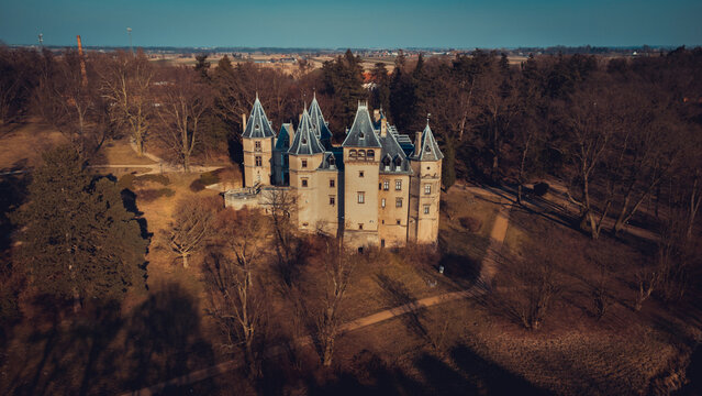 Old castle with a beautiful park in Goluchow, Poland. An aerial view drone photo in neutral colors.