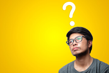 Man with question mark on his head and isolated yellow background.