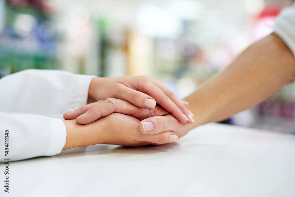 Wall mural Kindness goes a long way towards healing. Cropped shot of a pharmacist compassionately holding a customers hand.