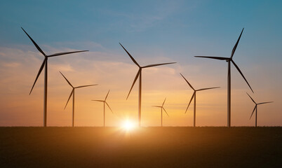 Silhouette of Wind turbines field against sunset sky background. Windmill, eco power. Green energy technology concept