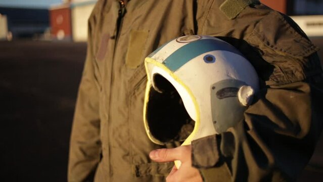 Fighter Pilot Holding His Helmet during Sunset. Midsection View.  