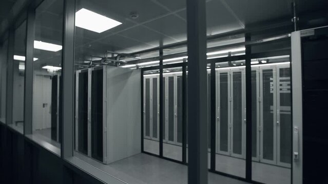 Shot of Corridor in Working Data Center Full of Rack Servers and Supercomputers with High Internet Visualisation Projection. IT sector, technologies concept