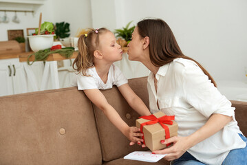 A young mother kisses her daughter and thanks her for the gift and the card.
