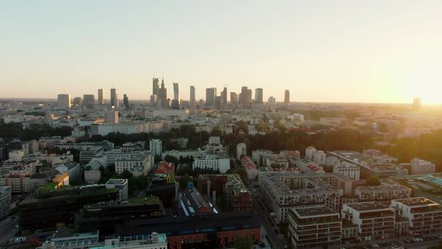 Establishing Aerial Panorama of Warsaw City Skyline - Capital of Poland, Europe. Modern Downtown Urban Cityscape with Vistula River quay. 4K drone zoom out shot